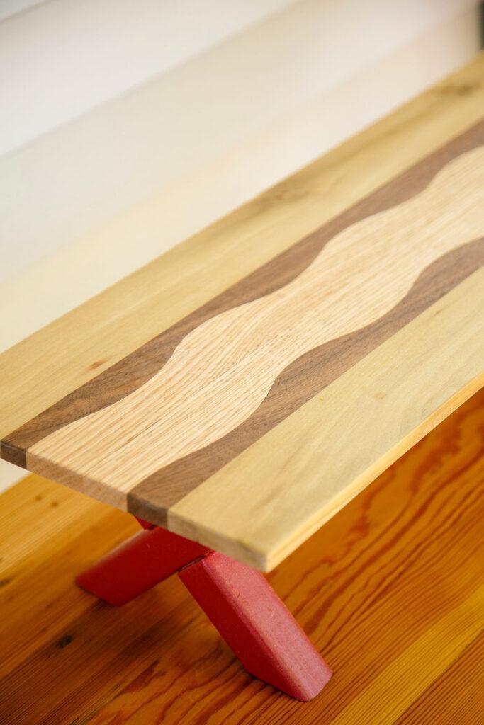 Upcycled kitchen organization shelf made by Upstate artisan featuring contrasting walnut, oak and tulip poplar in a wavy design. Sustainable home decoration for kitchen organization.
